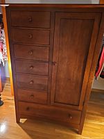 Front view of medium brown wood armoire closed