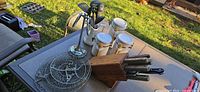 Overall lot on patio table showing knife block, canisters, utensil stand, wire baskets