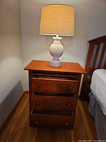 Nightstand with drawers open and lamp on top