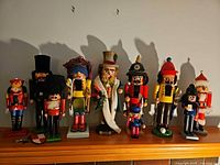Full group of nine Steinbach wooden nutcrackers on mantle