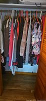 Closet rod with assorted women’s XL clothing on hangers