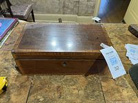 Closed wooden writing box showing exterior and lock