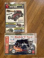 Both AMT box art prints in protective sleeves, showing illustrations and text