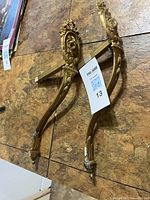 Both brass holdbacks shown full length on tabletop