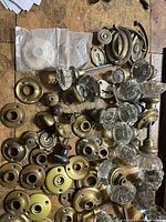 overview of glass knobs, brass rosettes, keyhole plates on tabletop