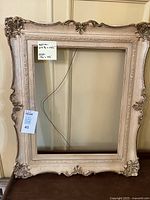 Cream ornate frame front view with lot tag