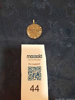Front view of sand dollar pendant with MaxSold marker
