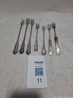 Seven assorted small antique forks arranged side by side