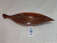 Top view of entire wooden nut dish next to scale card