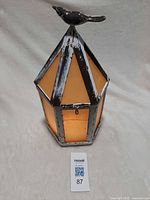 Full view of lantern showing shape, panels, bird finial