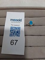 Ring on display beside lot card showing overall view