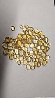 Pile of oval yellow citrine cabochons on white background