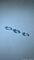 Three marquise blue topaz gemstones on neutral background