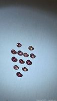 14 round sapphires arranged on white background