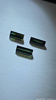 Three green baguette-cut tourmalines on white background