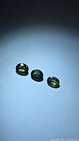 Three oval faceted sapphires arranged in a row