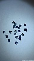 Group of small square blue sapphires on white background