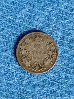 Reverse of 1885 25-cent coin displaying denomination, date and wreath