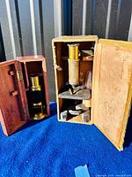 Both wooden cases open showing microscopes inside