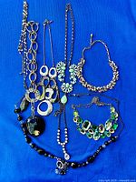 All nine necklaces laid out on blue background