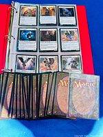 Binder open showing oversized cards in pockets and spread of regular cards