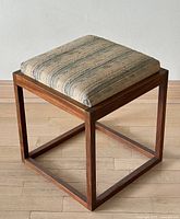 Full view of square teak stool on wood floor