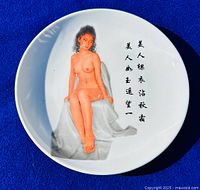 Front of porcelain plate showing nude female image and Chinese calligraphy