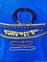 All eight necklaces laid out on blue background