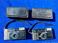 Two cameras and two cases laid out