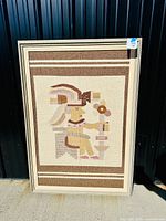 Full view of framed tapestry against wall