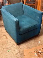 Front three-quarter view showing blue upholstered lounge chair with box arms and seat cushion