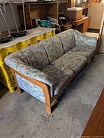Front angle of midcentury teak couch showing frame and upholstery