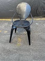 Front view of black metal chair with wood seat and backrest
