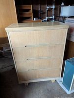 Front view of white oak dresser showing drawer fronts and feet