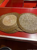 stack of gold beaded placemats on tabletop