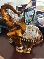Brown carved wood elephant with silver accents