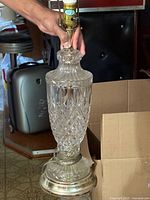 Full view of one crystal lamp showing cut glass body, metal base, and socket