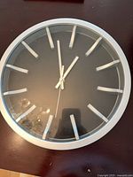 Front view of IKEA round wall clock showing frame, dial, hands and indices