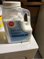 Front view of Life Brand Epsom salts container showing label, handle, and visible contents
