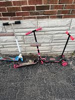 Front view of all three scooters against wall