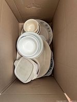 Top view of box showing stacked plates, bowls and CorningWare casserole