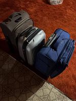 Front angled view of all three suitcases standing upright