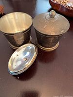 Pair of silver-plate cups with lids shown, highlighting exterior tarnish and beaded band