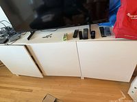 Front view of white TV stand with three doors