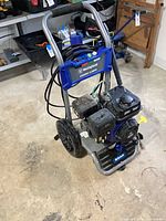 Front view showing full washer, wheels, frame and hose