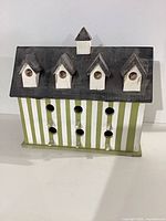 Front view of wooden striped birdhouse with multiple openings
