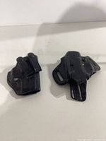 Two black Galco handgun holsters, IWB on left, OWB on right