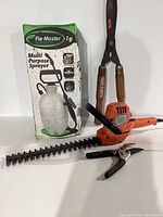 Group showing pump sprayer box, electric hedge trimmer, hedge shears, hand pruner