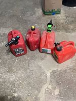 All four gas cans on concrete floor