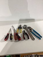 All eight hand tools laid out on white surface, showing overall contents